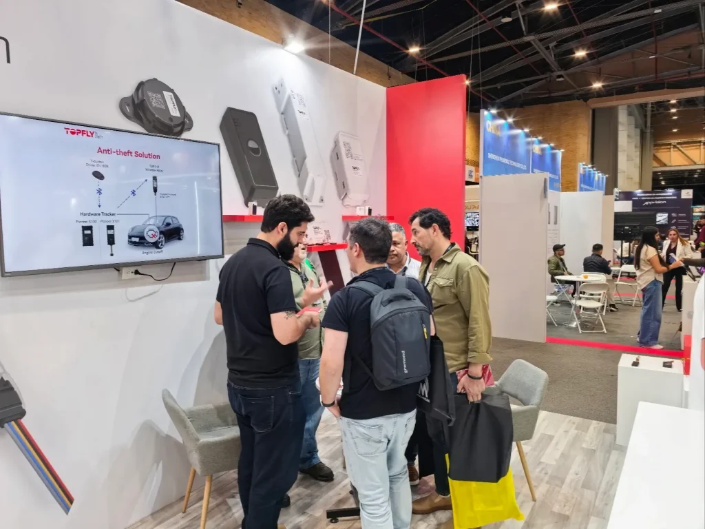 TOPFLYtech team discussing fleet tracking and asset monitoring applications with industry professionals at ESS+ 2026 in Bogotá.